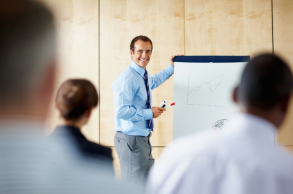 View of executive giving presentation with group of people in foreground